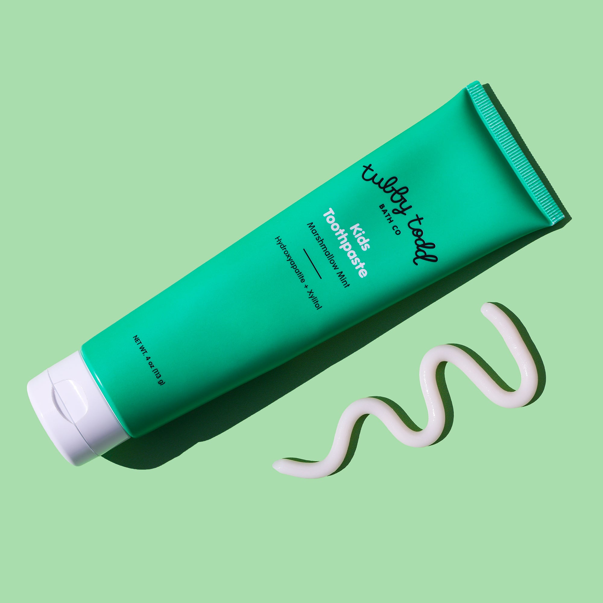 Marshmallow Mint toothpaste tube with white toothpaste on a light green background